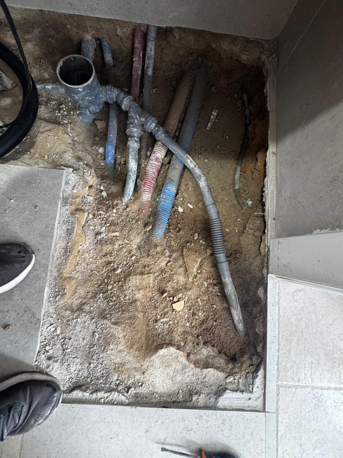 Floor opened to access leaking bathroom waste pipework